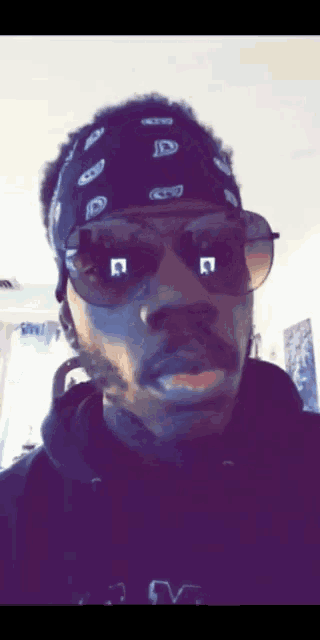 a man wearing sunglasses and a bandana with letters jd
