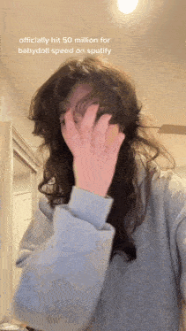 a woman covering her face with her hands and a caption that says officially hit 50 million for babydoll speed on spotify