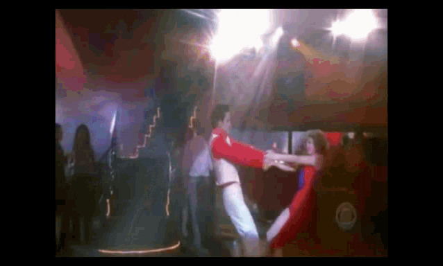 a man and a woman are dancing on a stage in front of a crowd .