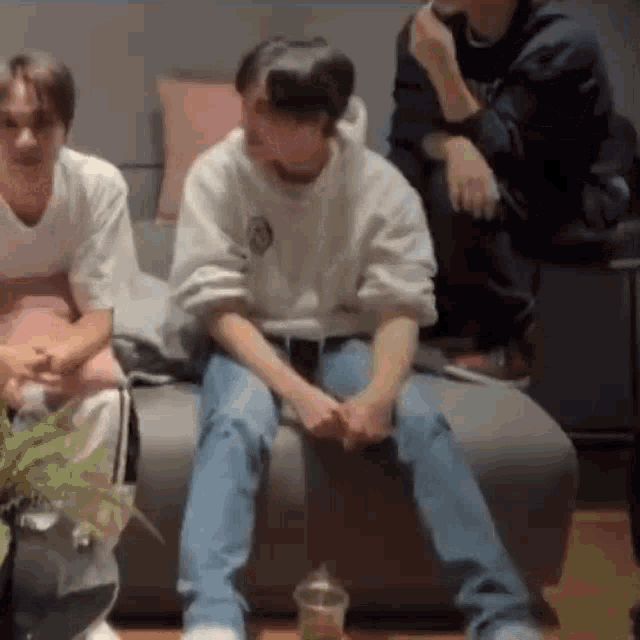 a group of people are sitting on a couch with their legs crossed .