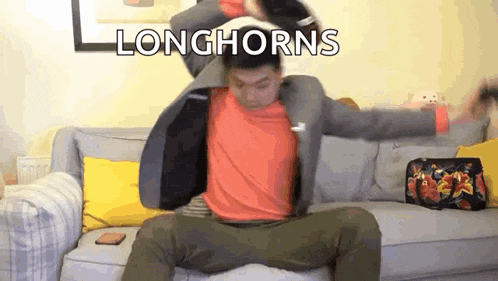 a man in a suit is sitting on a couch with his arms outstretched and the words longhorns above him