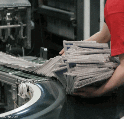 a person in a red shirt holds a stack of newspapers