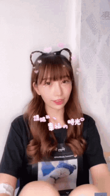 a girl wearing a cat ear headband and a t-shirt that says m4t