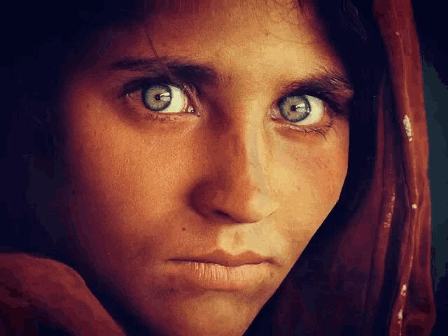 a close up of a woman 's face with a scarf around her head