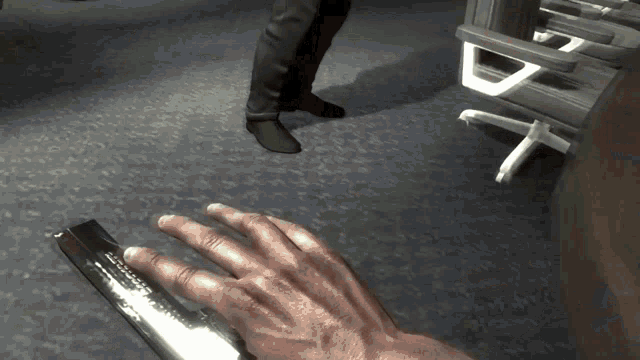a person 's hand is holding a metal object that says ' a ' on it