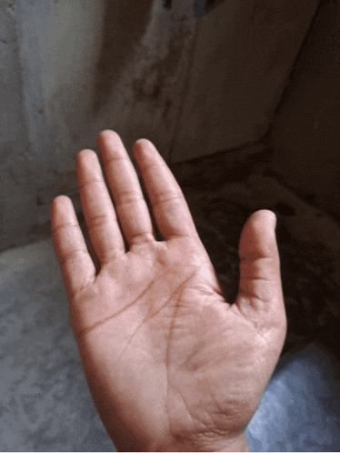 a close up of a person 's hand against a gray background