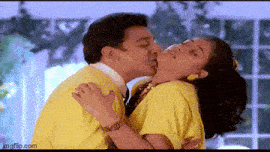a man and a woman are kissing in a room .