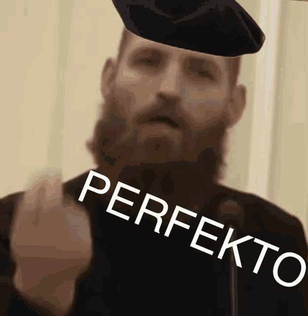 a man with a beard wearing a black beret with the word perfekto written on it