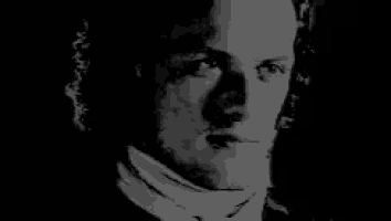 a black and white photo of a woman 's face with a dark background .
