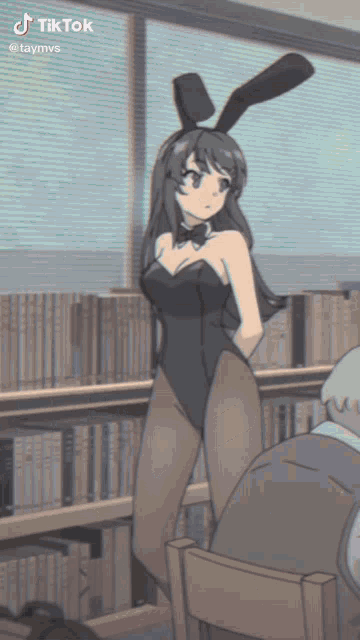 a girl in a bunny suit stands in front of a bookshelf