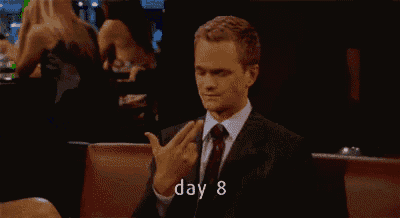 a man in a suit and tie is yawning while sitting at a table with the words day 8 above him .