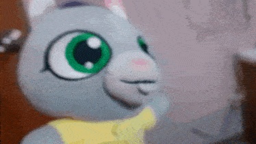 a stuffed animal with green eyes and a yellow scarf on .