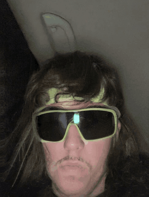 a man with a mustache wearing sunglasses and a headband with the letter s on it