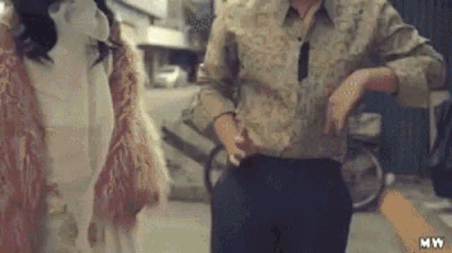 a man and a woman are standing next to each other on a sidewalk .