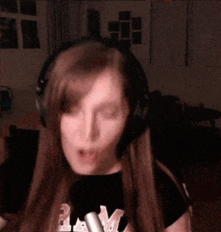 a woman wearing headphones is singing into a microphone