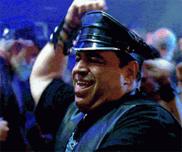 a man wearing a leather vest and a hat with the letter s on it