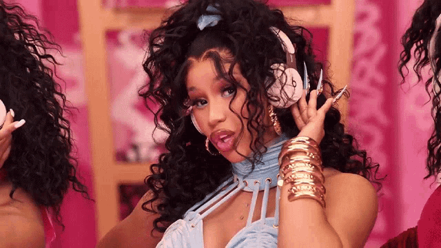 a woman with curly hair is wearing headphones .