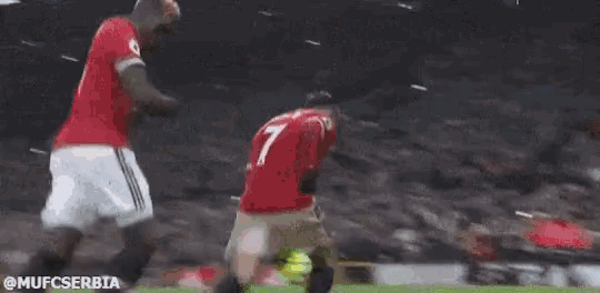 two soccer players are kneeling down on the field .
