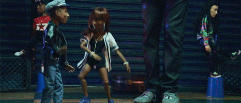 a group of dolls are dancing in front of a man wearing a hat that says ' captain ' on it