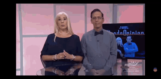a man and a woman are standing in front of a tv screen that says " opinion " on it