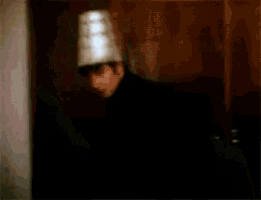 a blurry picture of a man in a black jacket standing in a dark room .