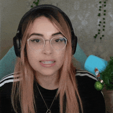 a woman wearing glasses and headphones is smiling for the camera