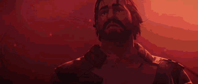 a man with a beard is standing in front of a red background .