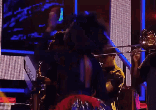 a man playing a trombone in front of a crowd