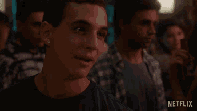 a group of young men are standing in a dark room with netflix written on the bottom