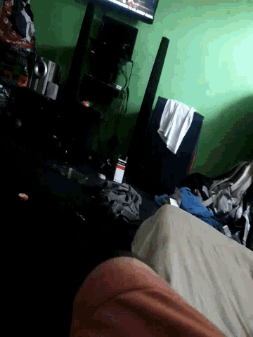 a person laying on a bed in a room with a tv on the wall