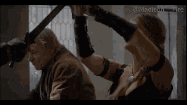 a man and a woman are holding swords in front of a window with the words madison fire below them