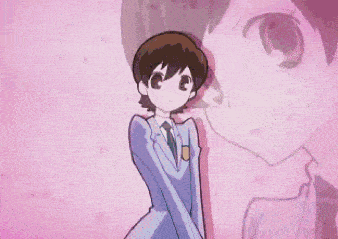 a boy in a suit and tie is standing in front of a pink wall