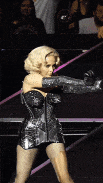 a woman in a corset and gloves is dancing on stage