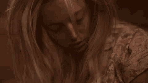 a close up of a woman with her eyes closed and her hair blowing in the wind