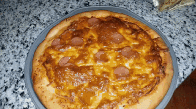 a pepperoni pizza is sitting on a marble counter