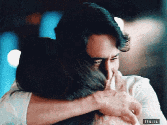 a man and a woman hugging with a tanuja sticker on the bottom