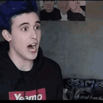 a young man with blue hair is wearing a black sweatshirt with a red supreme logo on it .