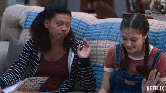 two girls sit on a couch with a netflix logo on the bottom