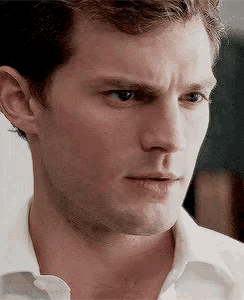 a close up of a man 's face in a white shirt looking at the camera .