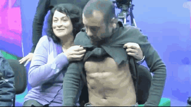 a woman is putting her arm around a man 's shoulders
