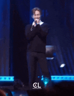 a blurry photo of a man on a stage with the letters cl on the bottom right