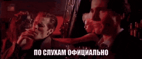 two men in suits and ties are talking to each other in a bar .