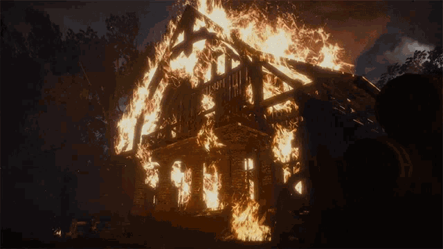 a house that has been burned to the ground and the roof is covered in flames