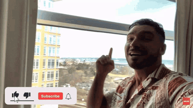 a man stands in front of a window with a subscribe button