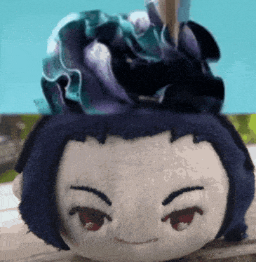 a stuffed animal with a purple flower on top of it 's head
