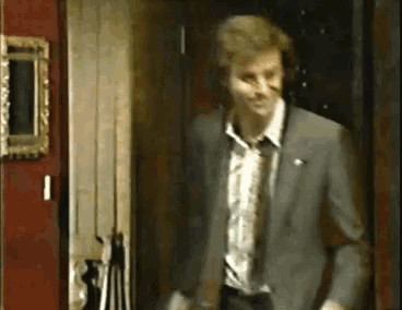 a man in a suit and tie is standing in a hallway .