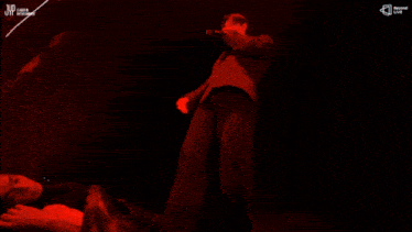 a man in a suit is holding a microphone in front of a screen that says jvc