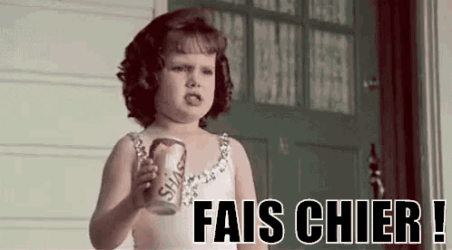 a little girl is holding a can of soda in front of a door .