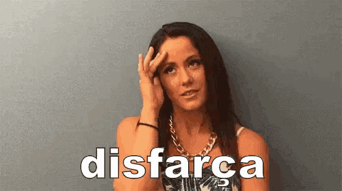 a woman is holding her hand to her forehead in front of a wall and the word disfara is written on the bottom .