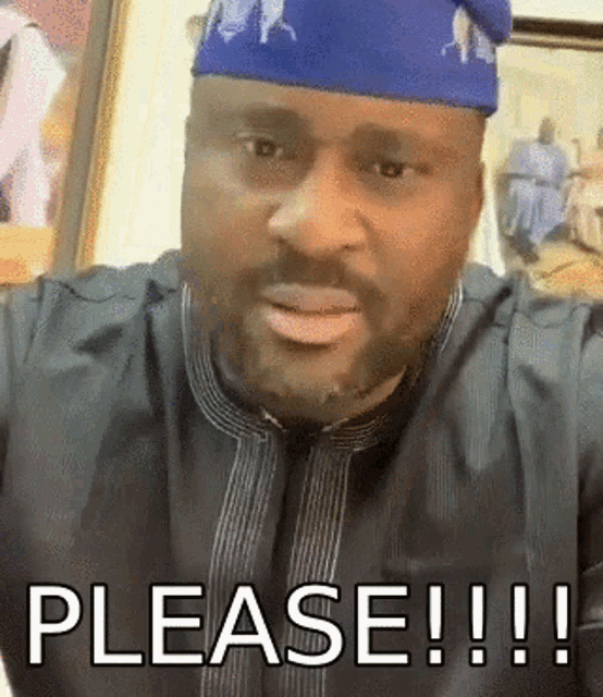 a man wearing a blue hat and a black shirt says please